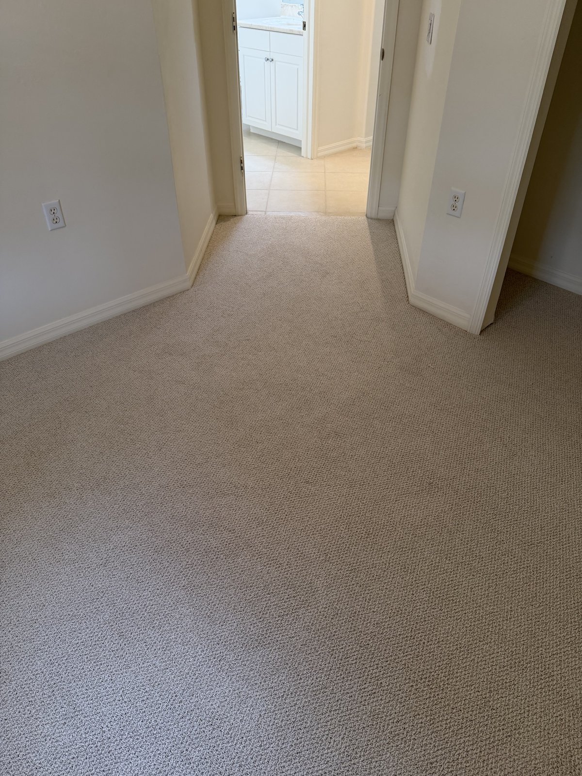 Fresh carpet on a landing meeting a tiled hallway